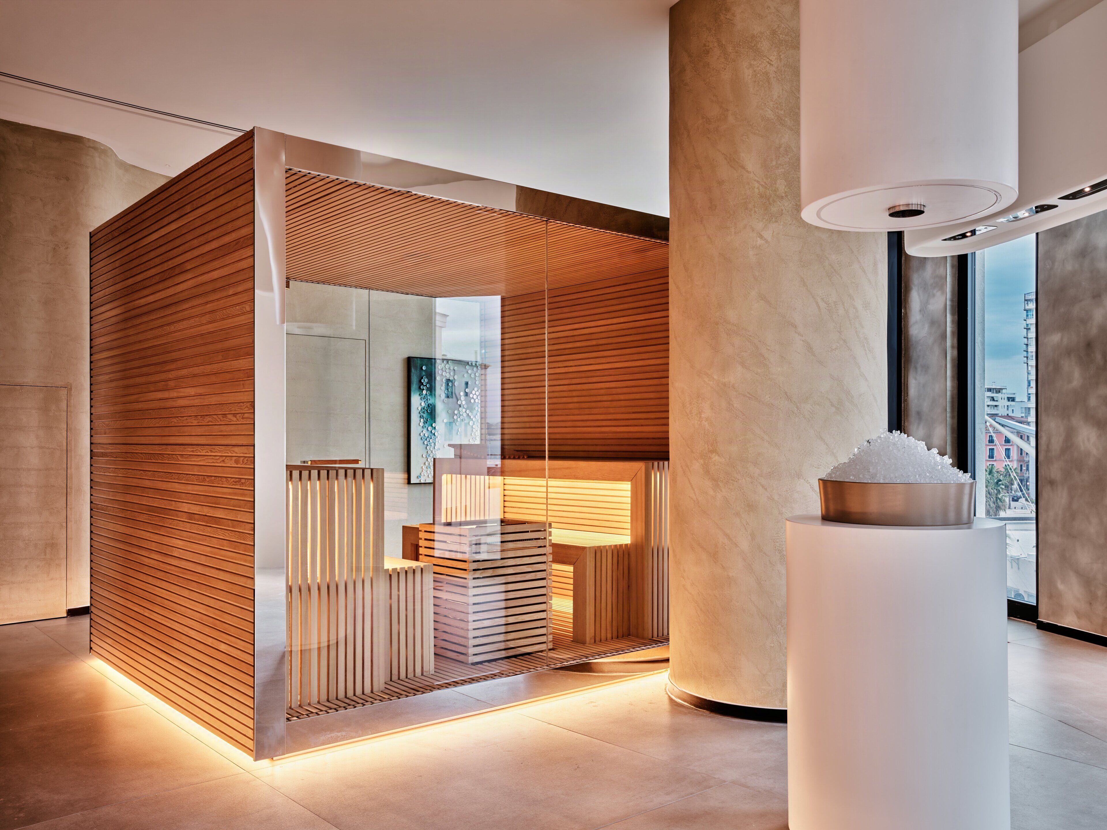 Un intérieur moderne agrémenté d’une cloison en bois, d’un mur en verre et d’un luminaire central.
