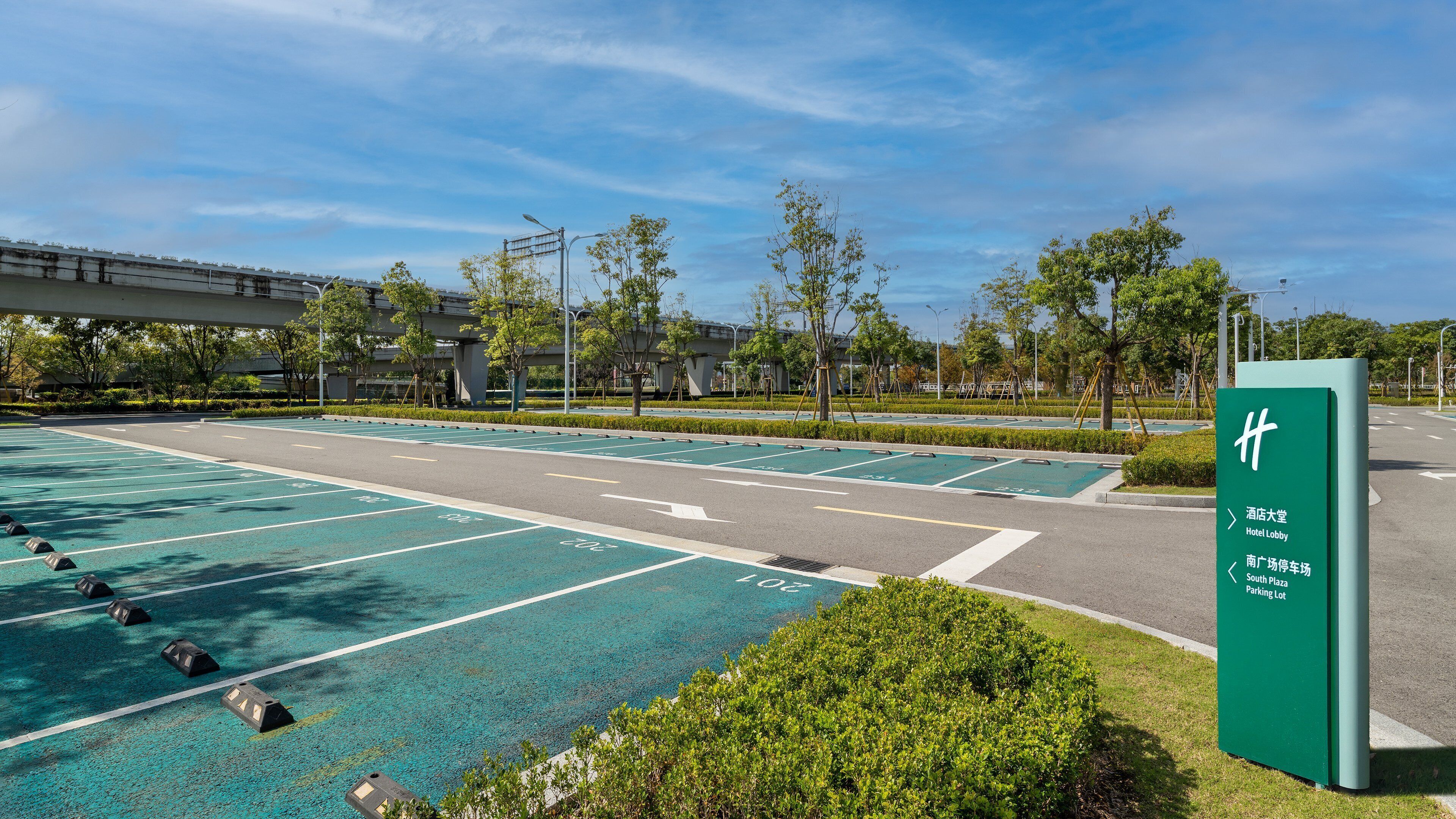 Un parking agrémenté d’espaces verts et de flèches indiquant la direction.