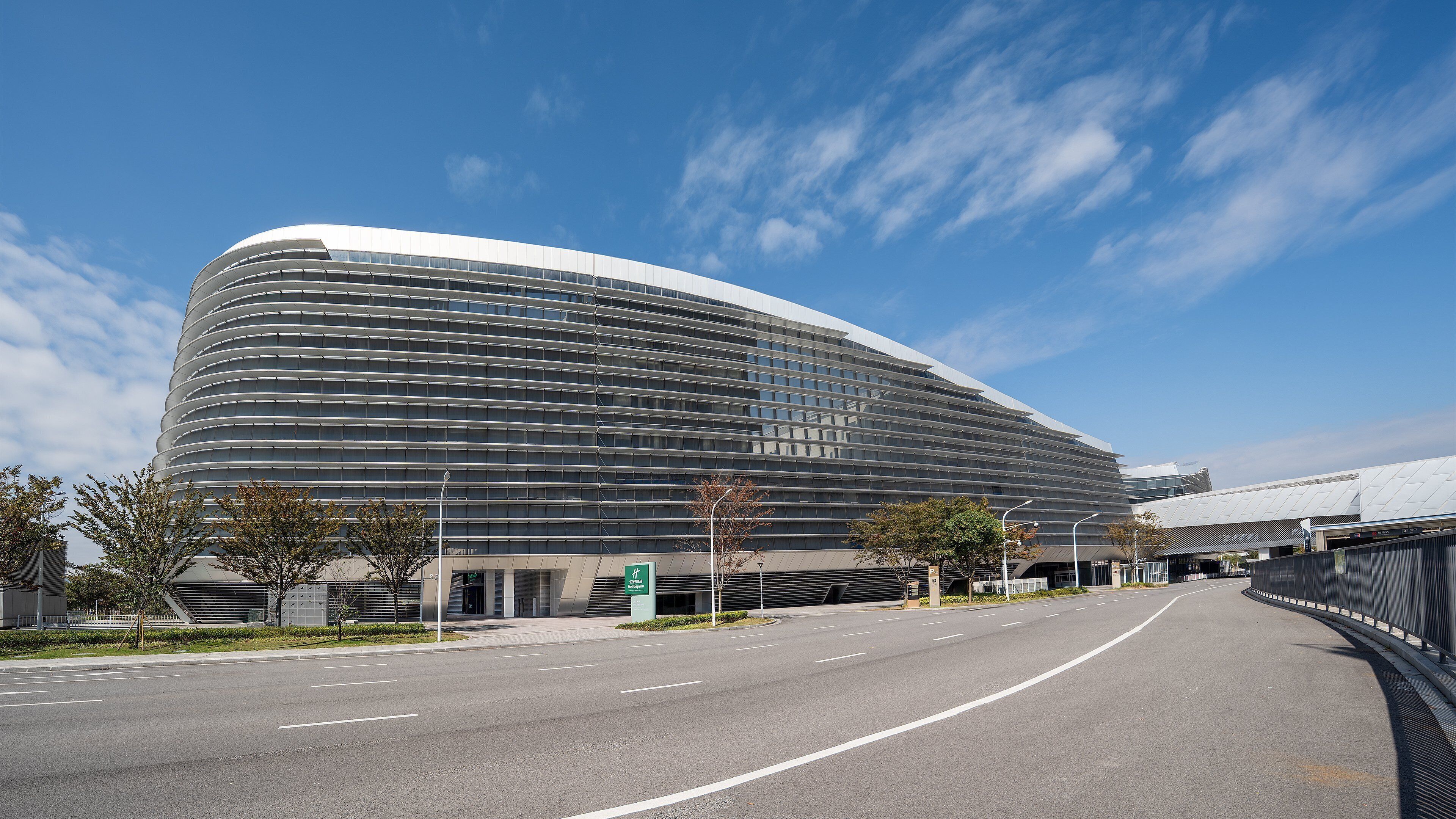 A modern building with a curved facade and multiple windows.
