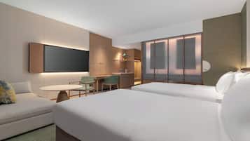 Une chambre d’hôtel comprenant un lit, un bureau avec une chaise, une télévision et un mini-bar.