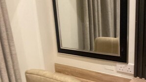 A room with a desk, a chair, a mirror, and a window with curtains. - Adar Hotel (Lagos)