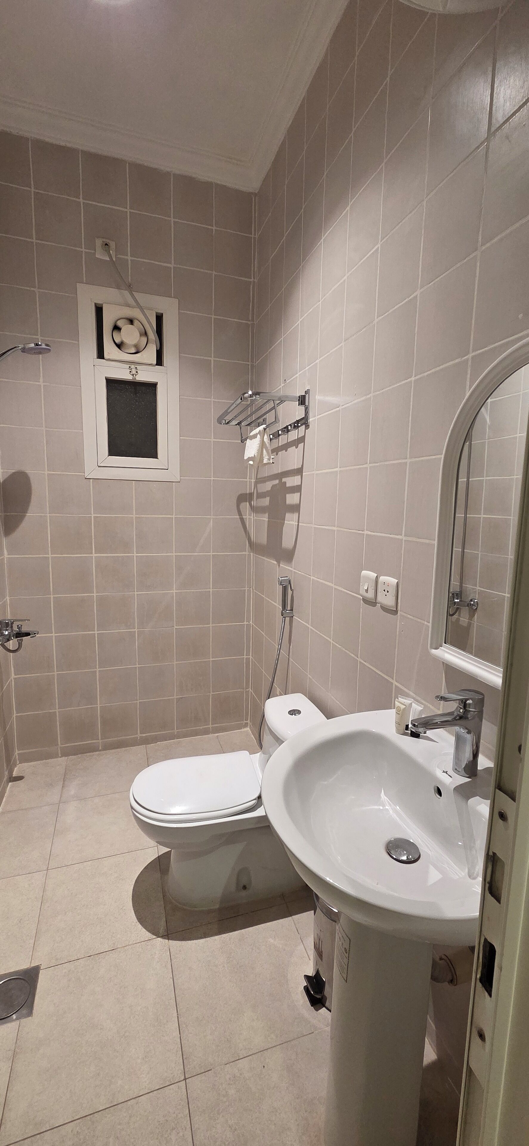 A bathroom with a toilet, sink, and shower.
