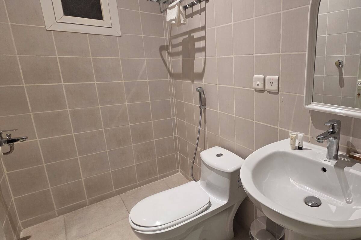 Familie tweepersoonskamer | Badkamer | Een haardroger, handdoeken, zeep, shampoo