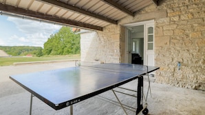 A ping pong table in an outdoor area with stone walls and a covered roof. - 2 bedroom amazing home in Monthenault (Monthenault)