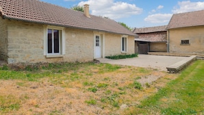 A courtyard with two rustic stone buildings, each with a tiled roof and a small window. - 2 bedroom amazing home in Monthenault (Monthenault)