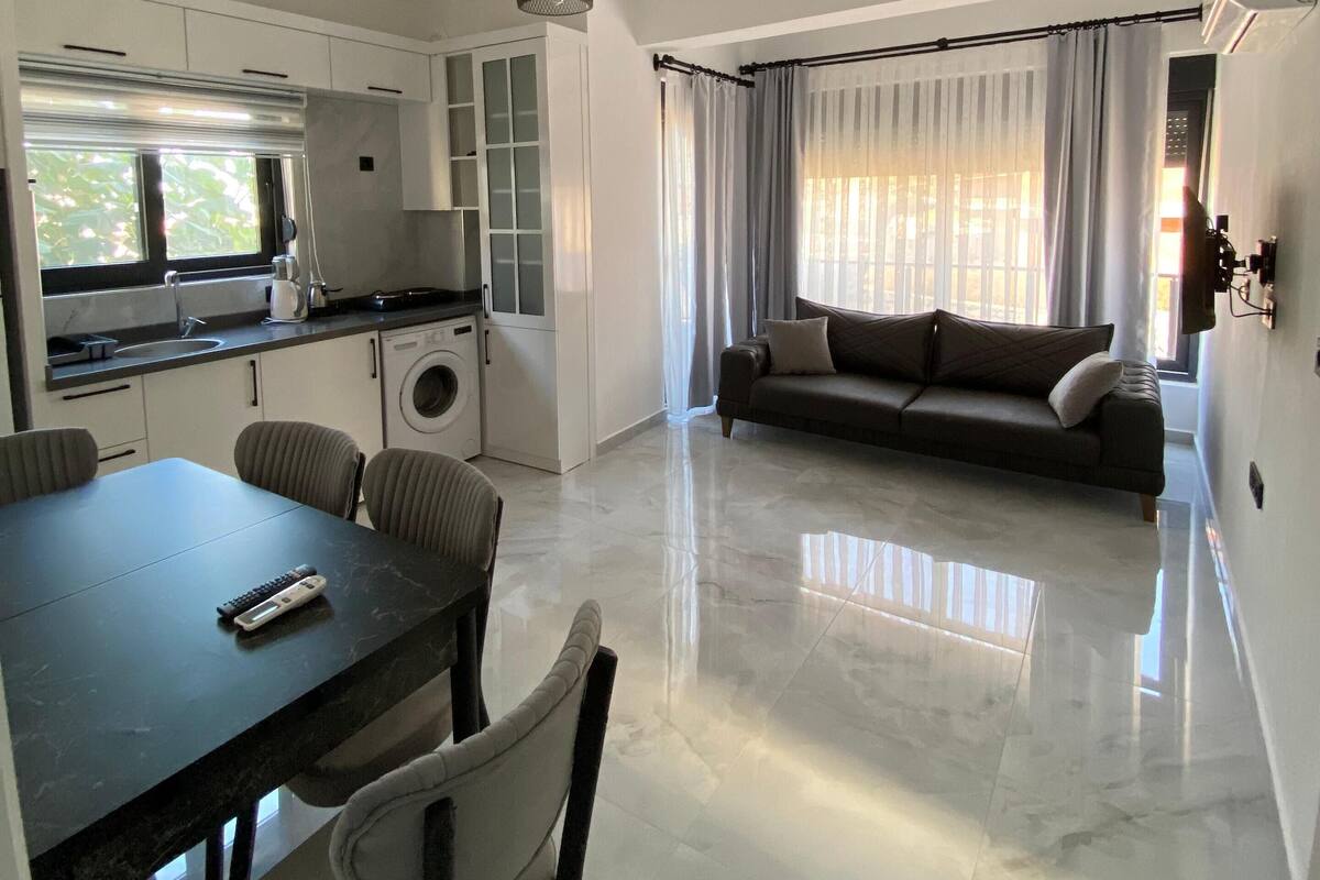 Un espacio de estar moderno con comedor, cocina y sofá en la sala.