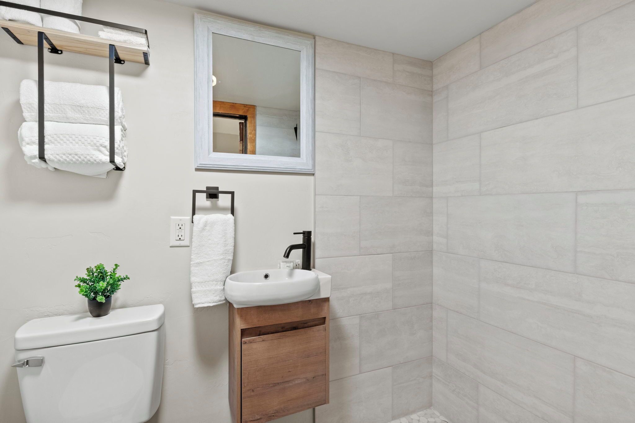 Une salle de bain avec des toilettes, un lavabo et un miroir.