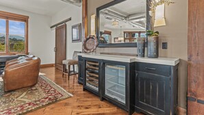 Une cuisine moderne dotée d’un réfrigérateur encastré, d’un grand miroir et d’un meuble en bois rustique.