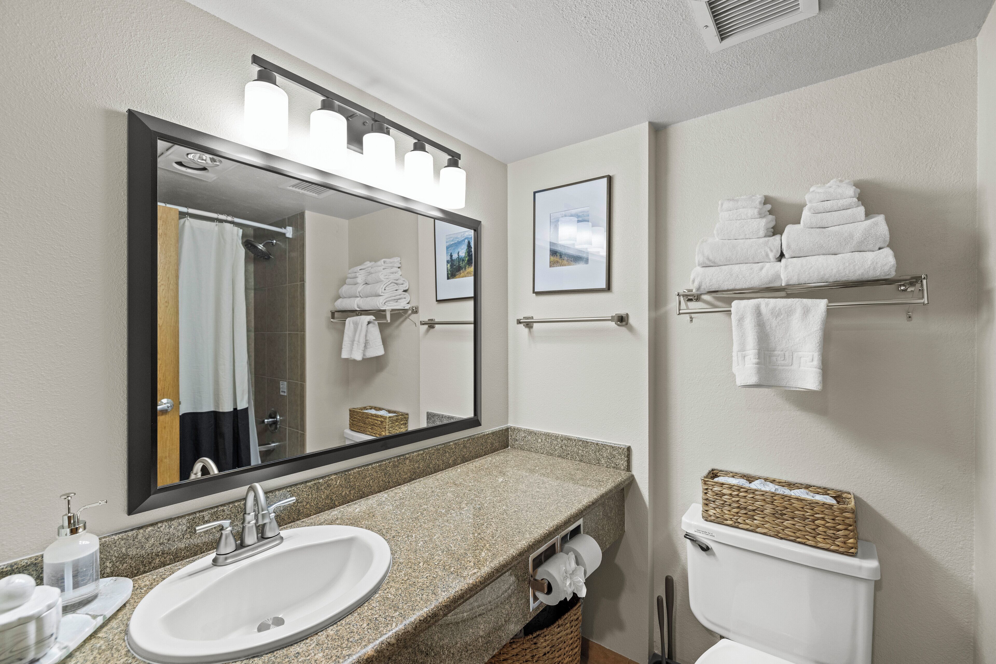 A bathroom with a sink, mirror, towel rack, and toilet.