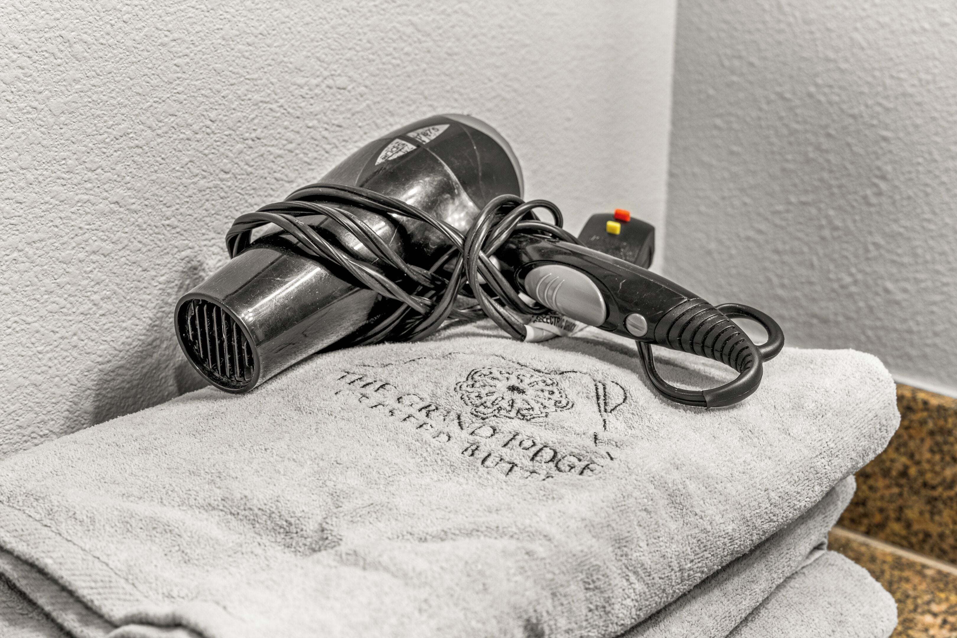 A hair dryer on a towel with the text "THE GRAND EDGE" visible.