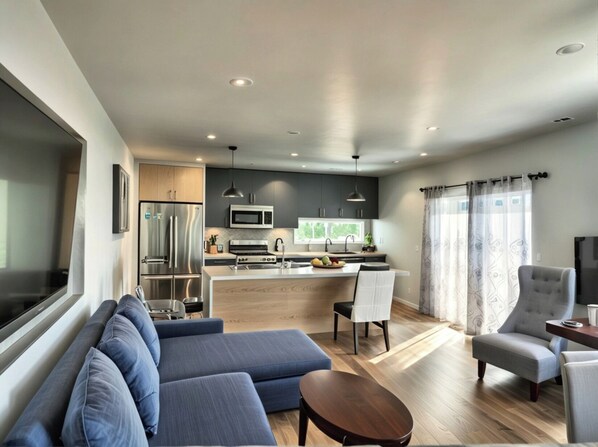 A modern living room with a sofa, a coffee table, and a TV.