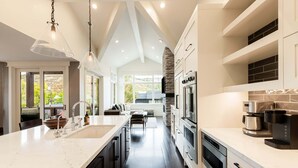 Una cocina moderna con una isla grande, electrodomésticos integrados y una chimenea de piedra.