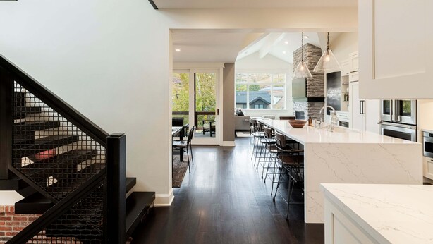 Una cocina moderna con encimera de mármol, horno empotrado y una pared decorativa de piedra.