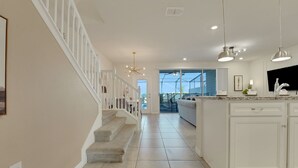 Una cocina amplia con armarios blancos, una isla grande y vistas al exterior.