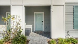 Un edificio moderno con una puerta azul claro, un buzón y el número 