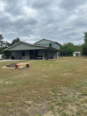 A two-story building with a covered patio area and a fire pit.