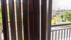 A balcony with dark wooden railings and a black table. - Le Nid de Thalys  Appartement de charme (Cayenne)