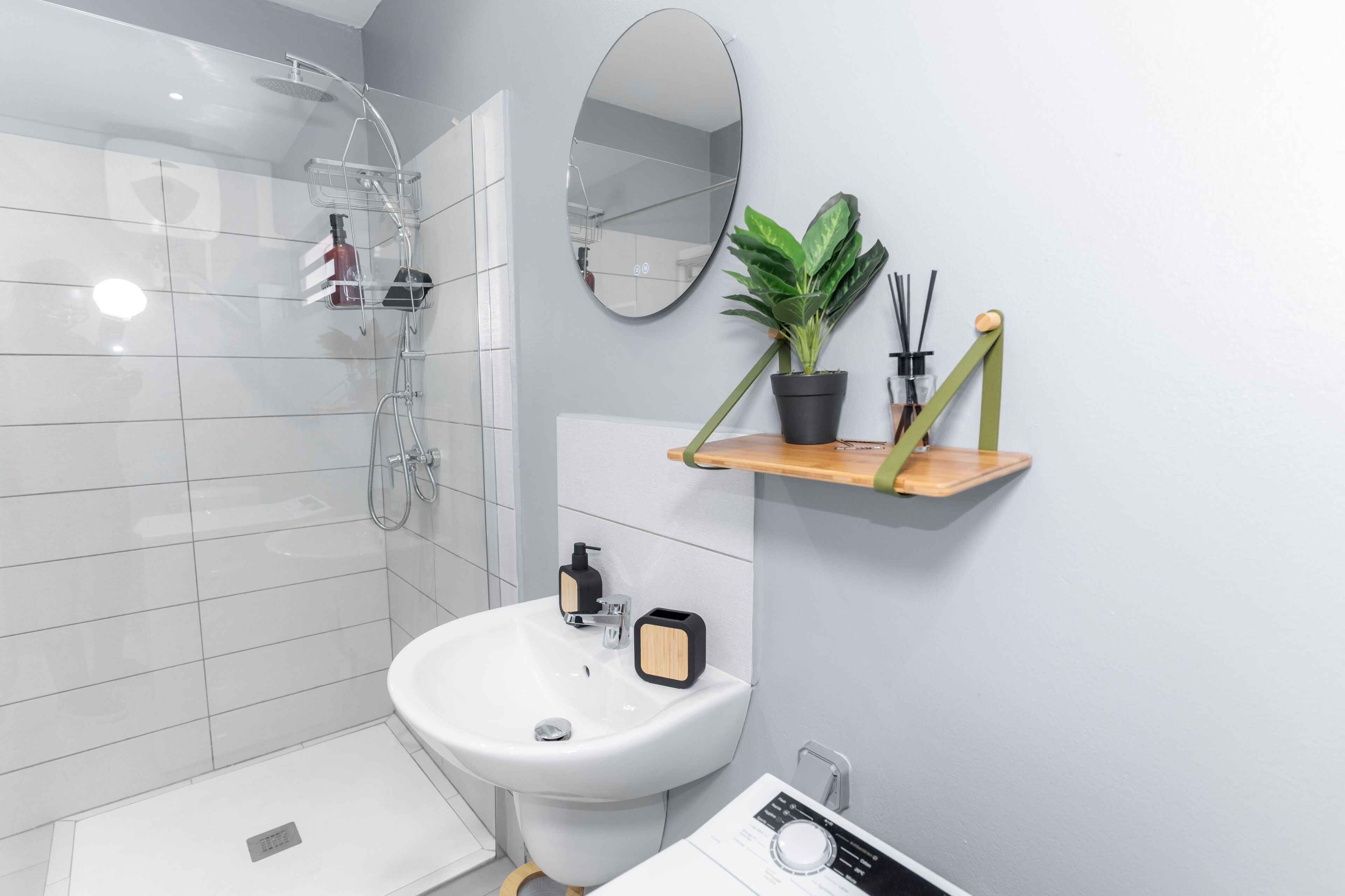 A modern bathroom with a shower, sink, and mirror.