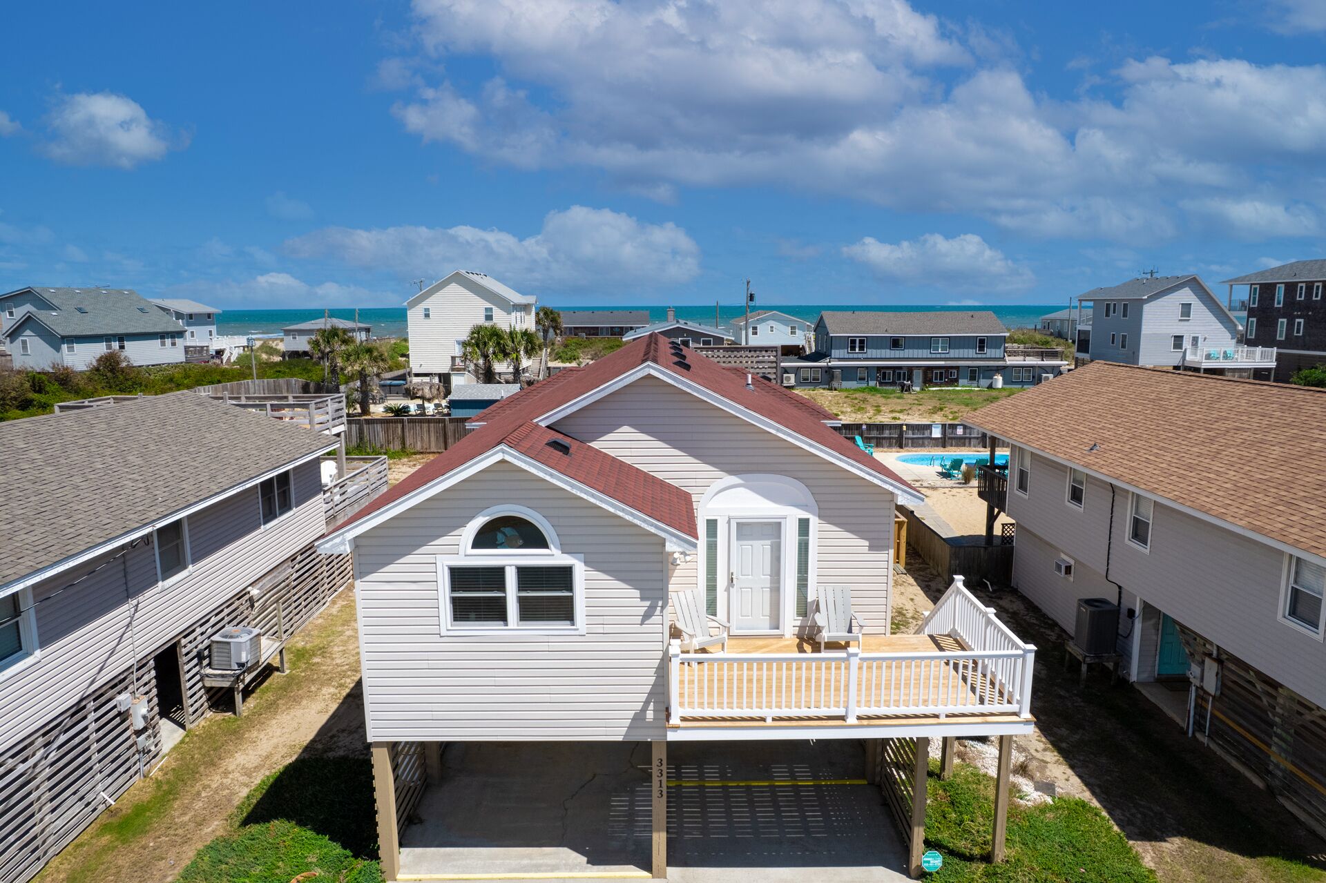 Un quartier résidentiel avec des maisons, une terrasse en bois et une piscine.