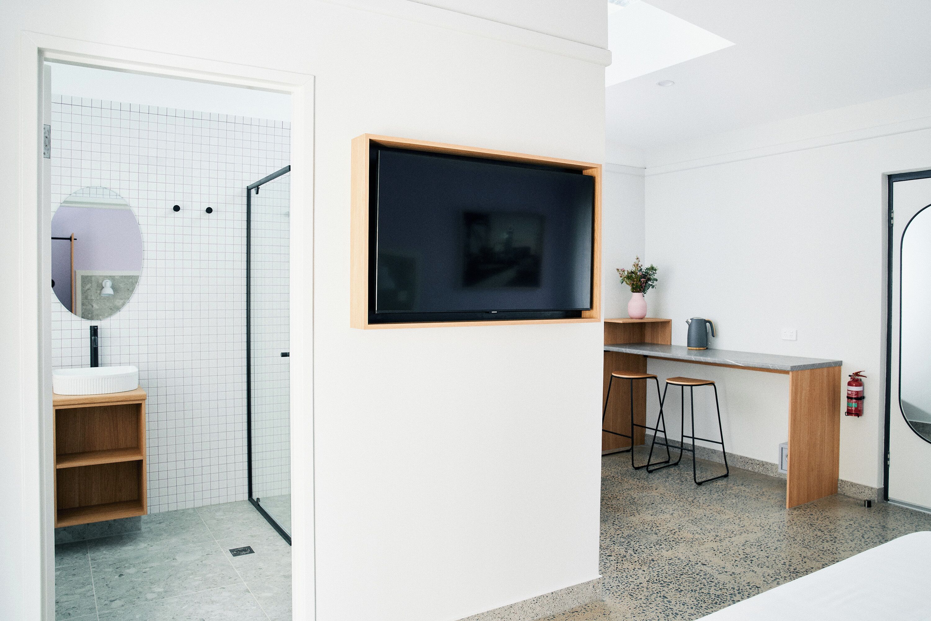 Une salle de bain moderne avec une douche, un lavabo et un miroir.