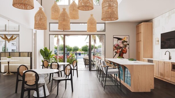 A modern kitchen with a wooden island, large windows, and a dining area with wicker chairs and a round table.