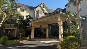 A hotel with a covered entrance, palm trees, and a clear blue sky. - Landing Bradenton Near G.T. Bray Park (Bradenton)
