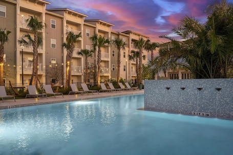 Una piscina al aire libre, tumbonas