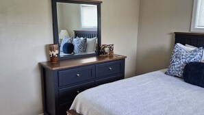 A bedroom with a bed, a dresser, a mirror, and a ceiling fan. - Serene 2-bedroom house in Indiana. (Indiana)