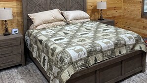 Camera da letto con rivestimento in legno, un letto, due comodini e un tavolino da notte.