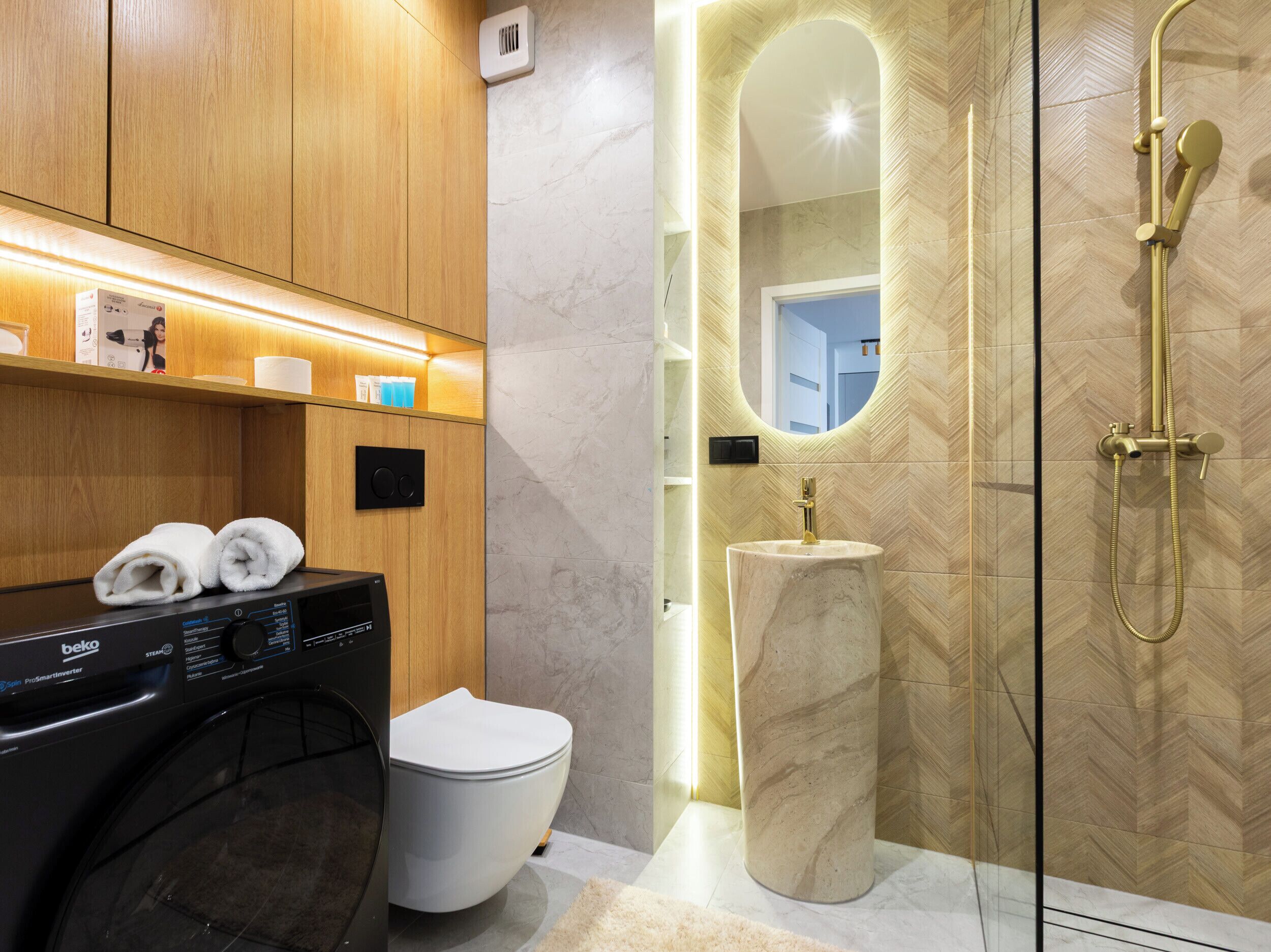 A modern bathroom with a wooden vanity, a toilet, a sink, and a shower area.