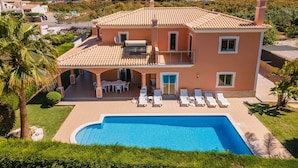 Une maison à deux étages dotée d’une piscine, d’un patio couvert et offrant une vue sur le paysage environnant.