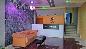 A reception area with a sofa, a reception desk, and a wall with a textured design. - Eastern Ark Hotel (Nguluni)
