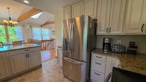 A modern kitchen with a stainless steel refrigerator, a coffee maker, and a toaster. - Barefoot Manor - 4 BR home w/Private Pool, just a short distance from the beach (Southern Shores)
