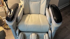 Ein Massagesessel mit Bedienfeld, Fußstütze und Fußmassagegerät.