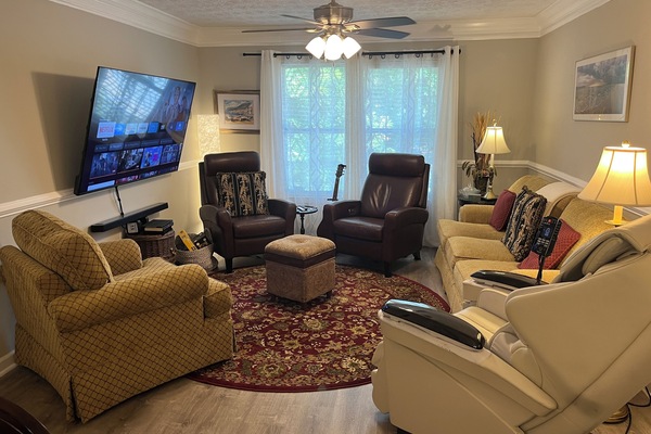 Living room features a 70 inch TV, seating for 7, & full body massage chair