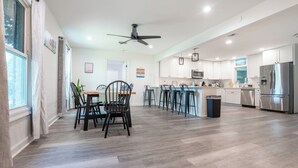 A spacious kitchen with modern appliances, a dining area with chairs, and a ceiling fan. - Spacious 4-bedroom house in Fort Walton Beach with lots of parking. (Fort Walton Beach)
