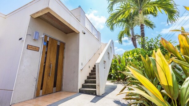 A modern building with a wooden door and a staircase leading to a second floor. - Exclusive view of the star-filled sky on the rooftop terrace. Walking distance from Imgarma Marine Garden (1.1km). Privileges: Free Miyako soba noodles, BBQ set rental, and star photography can be arranged. Unattended check-in support. (Miyaknjima)