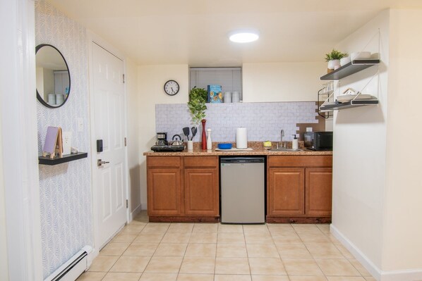 Una cocina compacta con armarios de madera, lavavajillas y una pequeña encimera.