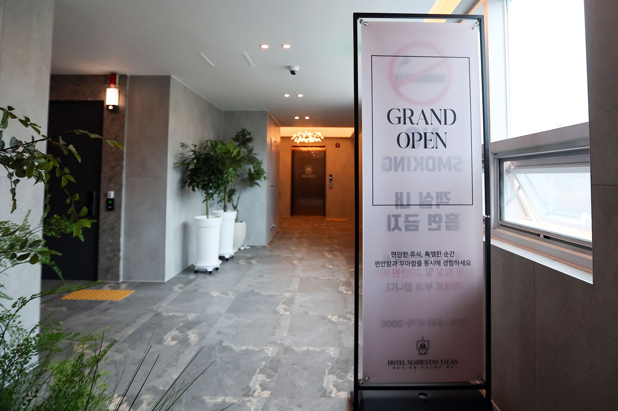 A hotel corridor with a sign indicating the Grand Open Smoking area.