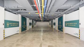 A clean, modern hotel corridor with multiple rooms, including rooms 202 and 212, and visible HVAC ducts.