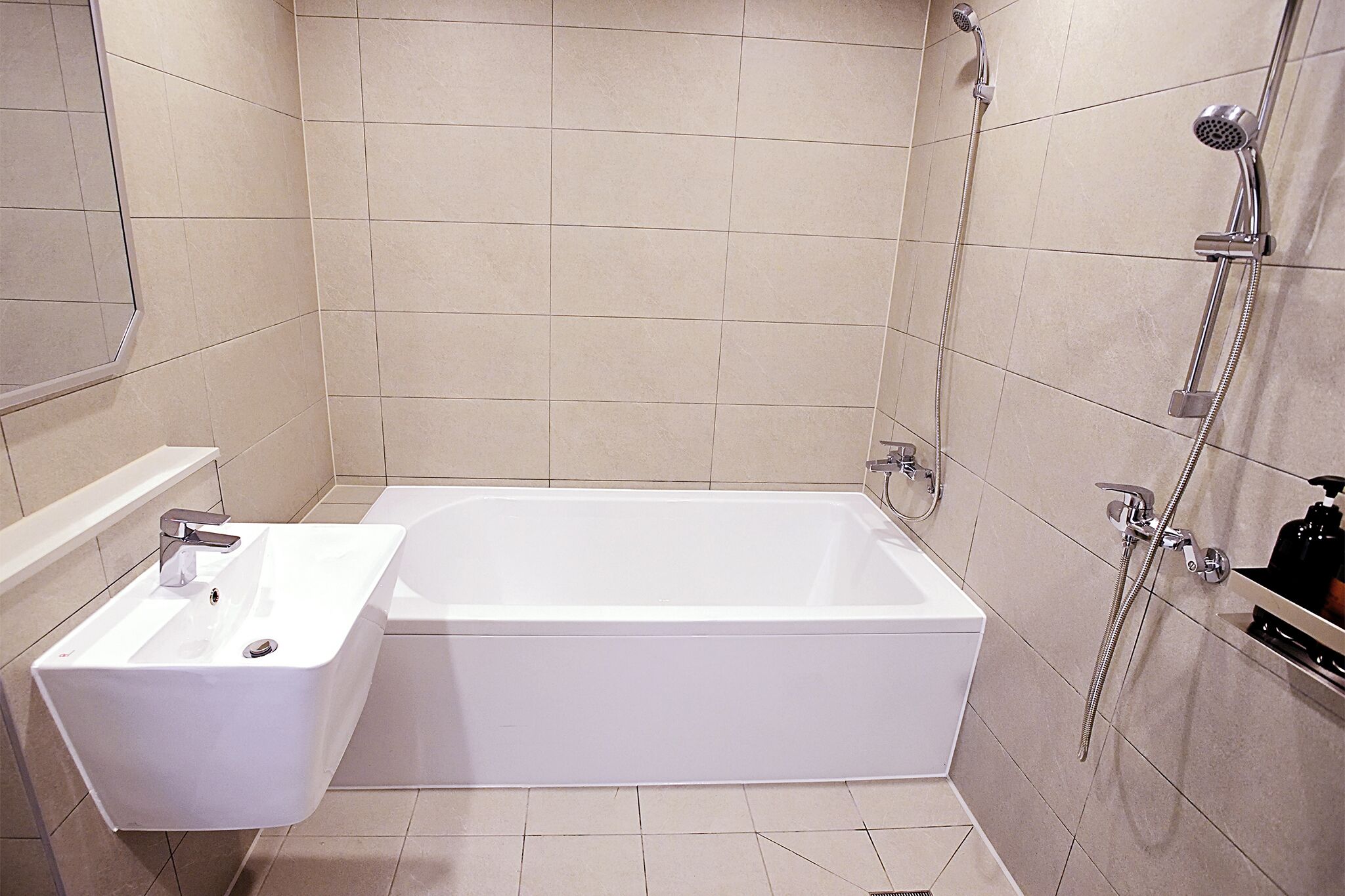 A bathroom with a white bathtub, a sink, and a shower area.
