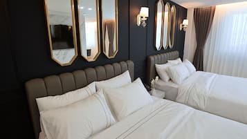 A hotel room with two beds, dark walls, and large mirrors.