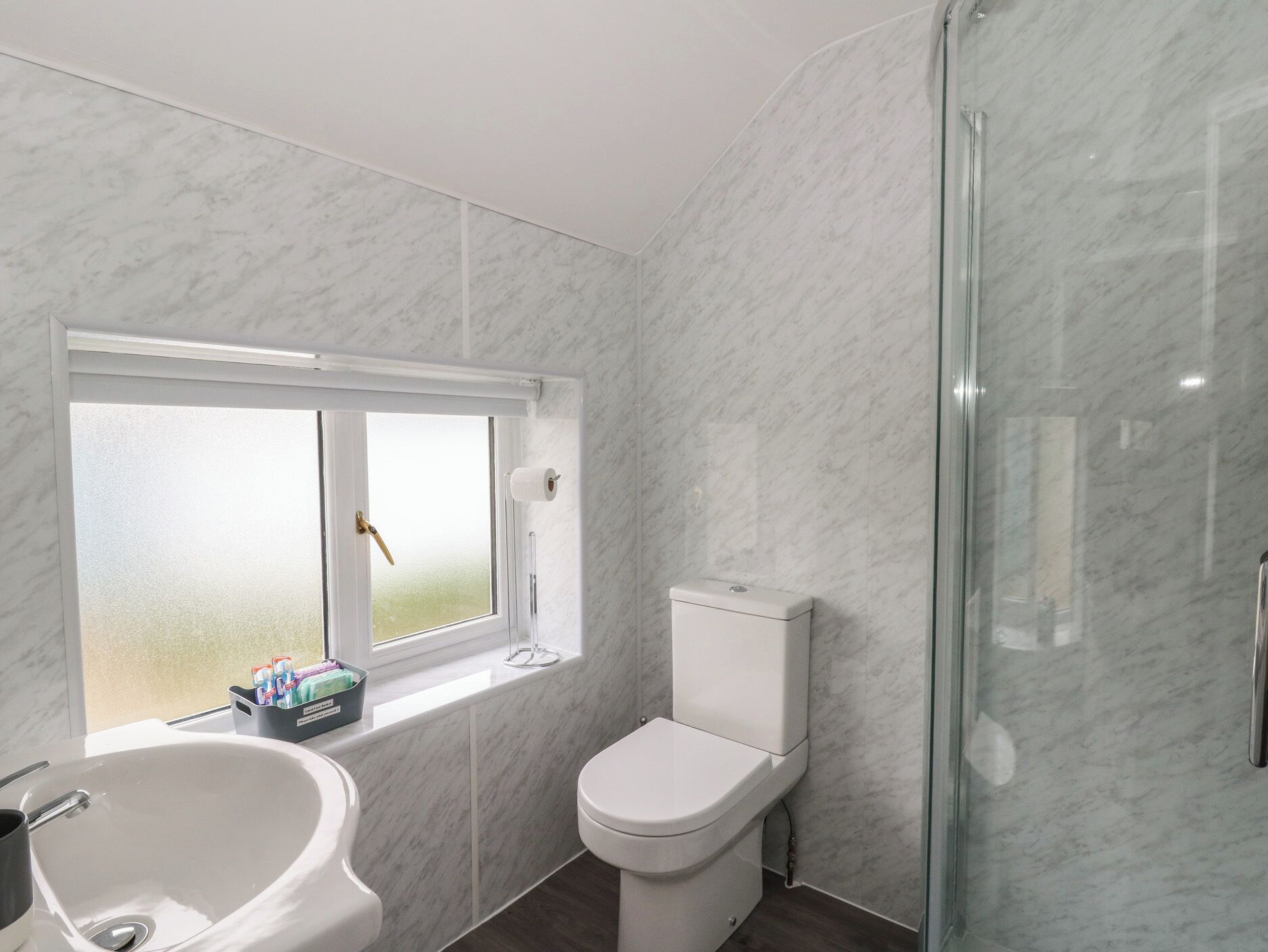 A bathroom with a toilet, a sink, and a shower.