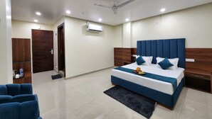 A modern bedroom with a large bed, a ceiling fan, recessed lighting, and a built-in air conditioning unit. - Hotel Robo Nest (Balichauki)