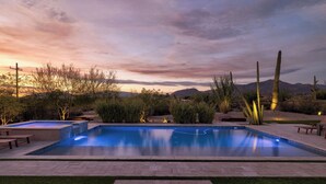 Une piscine avec vue sur les montagnes et sur le coucher de soleil.