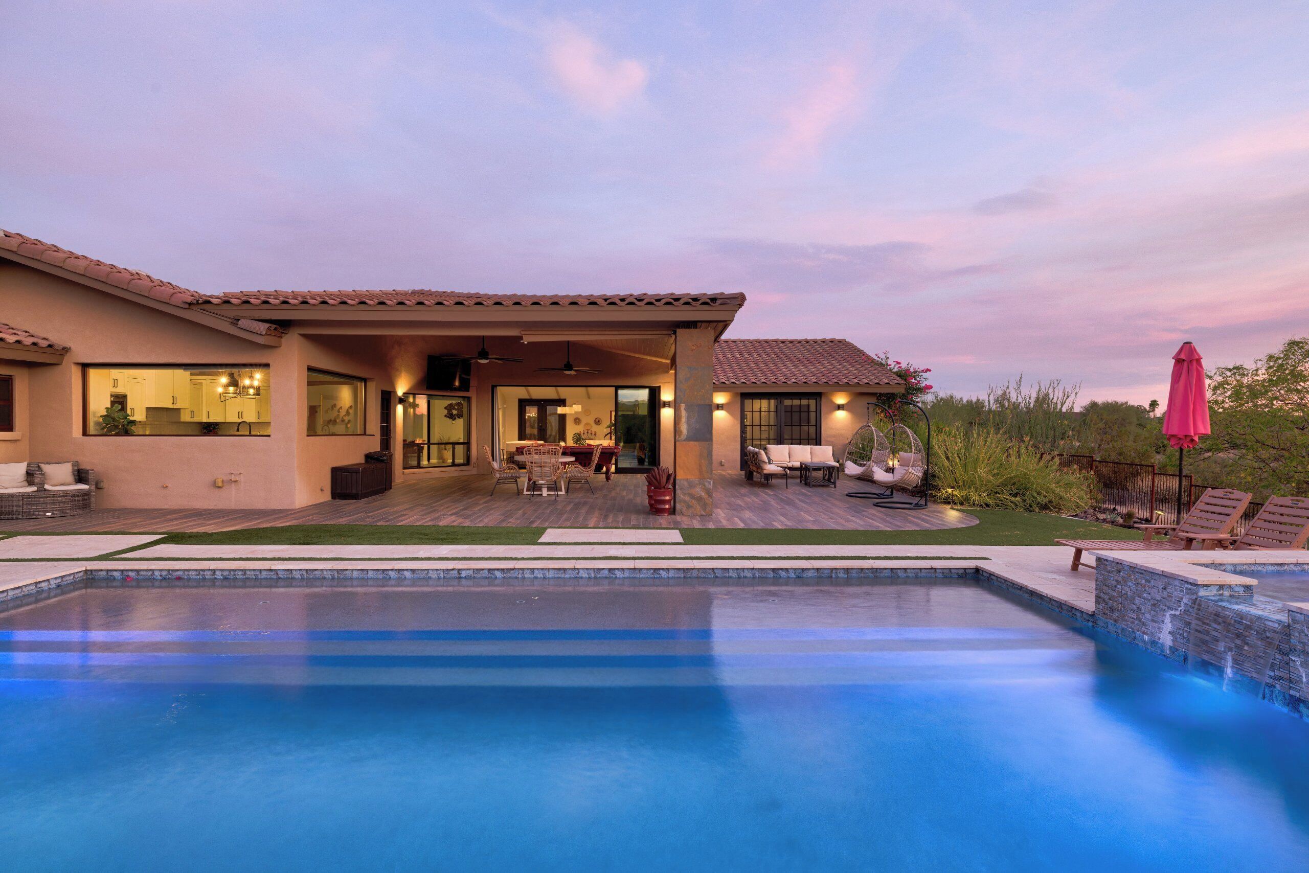 Una propiedad residencial con piscina, zona de estar al aire libre y patio cubierto.