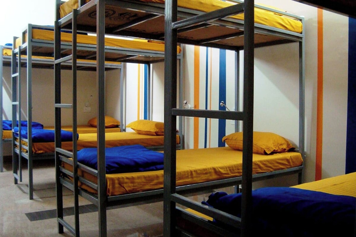 Camas literas con ropa de cama amarilla y azul en un dormitorio.