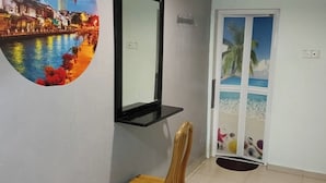 A room with a wooden chair, a door with a beach mural, and a wall-mounted mirror.