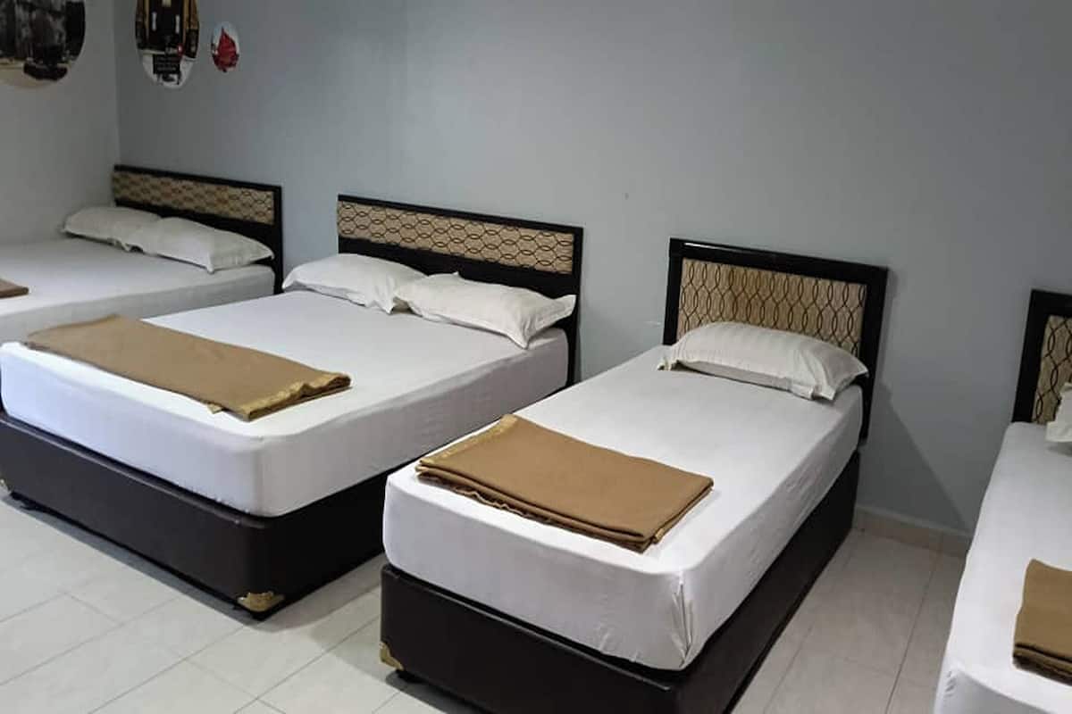 Three single beds with headboards, white bedding, and brown blankets.