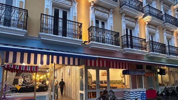 A street with a café and a restaurant with outdoor seating.